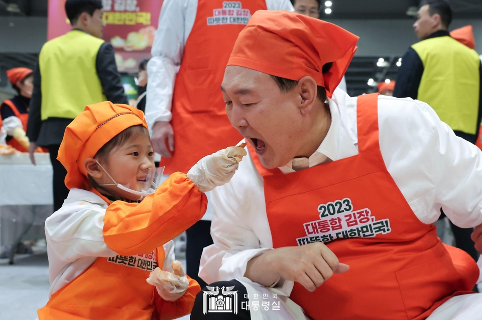 윤석열 대통령이 27일 경기 고양시 킨텍스에서 열린 ‘나눔과 봉사의 국민 대통합 김장행사’에서 어린이가 담근 김치를 맛보고 있다.