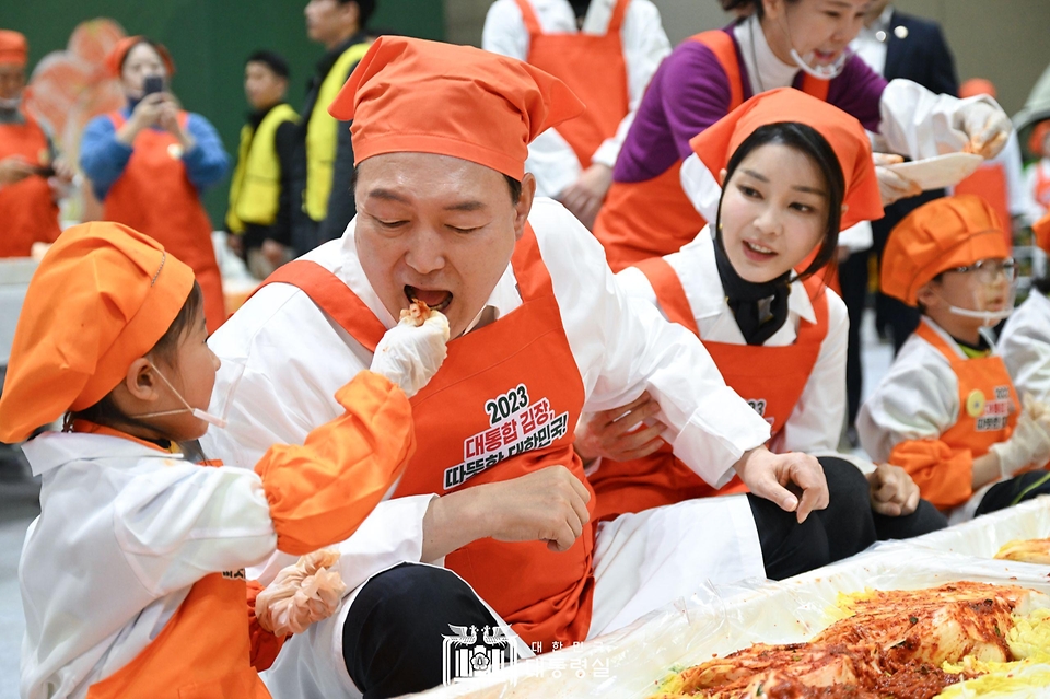 윤석열 대통령이 27일 경기 고양시 킨텍스에서 열린 ‘나눔과 봉사의 국민 대통합 김장행사’에서 어린이가 담근 김치를 맛보고 있다.