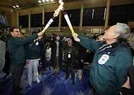 유인촌 문화체육관광부 장관이 28일 강원도 원주 육민관고 체육관에서 열린 ‘2024강원동계청소년올림픽 원주 성화투어 행사’에 참석해 김재열 IOC 위원에게 성화를 인계 받고 있다.