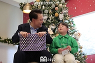 윤석열 대통령이 22일 서울 용산 대통령실 청사에서 열린 ‘히어로즈 패밀리와 함께하는 꿈과 희망의 크리스마스 행사’에서 어린이들에게 선물을 전달하고 있다.