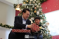 윤석열 대통령이 22일 서울 용산 대통령실 청사에서 열린 ‘히어로즈 패밀리와 함께하는 꿈과 희망의 크리스마스 행사’에서 어린이들에게 선물을 전달하고 있다.