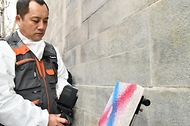이태종 국립문화재연구원 학예연구사가 4일 서울 종로구 경복궁 영추문에서 레이저 장비를 활용해 낙서 제거 작업을 시연하고 있다. 이날 문화재청은 낙서 제거 작업을 마친 경복궁 담장을 공개했다. 
