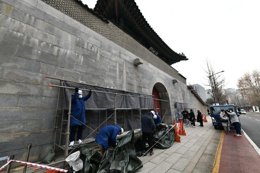 문화재청 관계자들이 4일 서울 종로구 경복궁 영추문에서 가림막을 철거하고 있다. 이날 문화재청은 낙서 제거 작업을 마친 경복궁 담장을 공개했다.