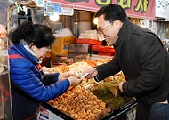 김병환 기획재정부 차관이 24일 서울 마포구 망원시장에서 온누리상품권으로 물품을 구매하고 있다.