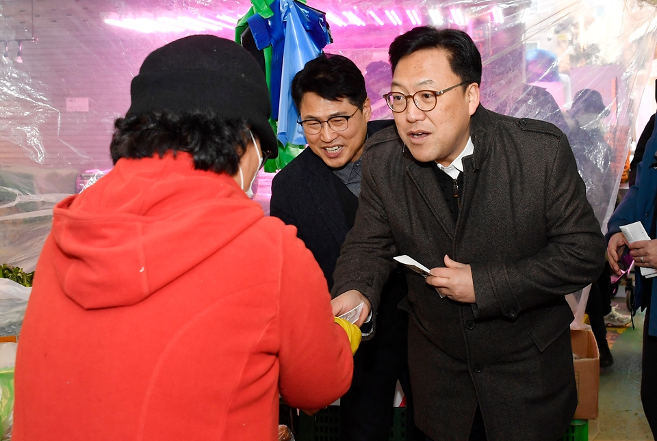김병환 기획재정부 차관이 24일 서울 마포구 망원시장에서 온누리상품권으로 물품을 구매하고 있다.
