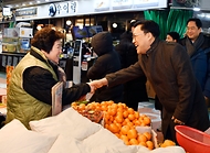 김병환 기획재정부 차관이 24일 서울 마포구 망원시장에서 시장 상인과 악수하고 있다. 
