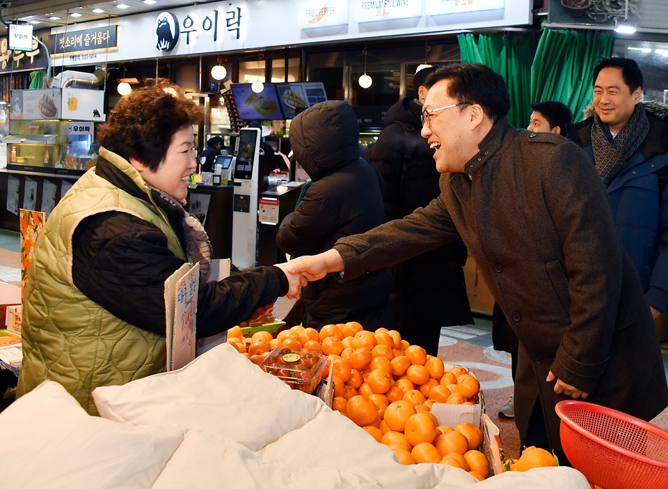 김병환 기획재정부 차관이 24일 서울 마포구 망원시장에서 시장 상인과 악수하고 있다. 