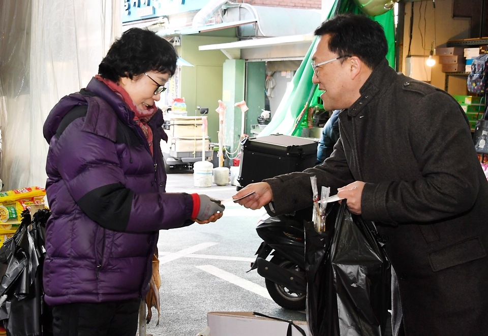 김병환 기획재정부 차관이 24일 서울 마포구 망원시장에서 온누리상품권으로 물품을 구매하고 있다.
