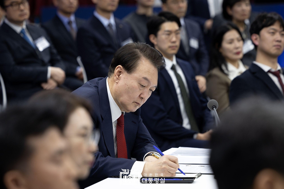 윤석열 대통령이 13일 부산시청에서 열린 ‘국민과 함께하는 민생토론회 - 열한 번째, 부산이 활짝 여는 지방시대’에서 토론자의 발언을 들으며 메모하고 있다.