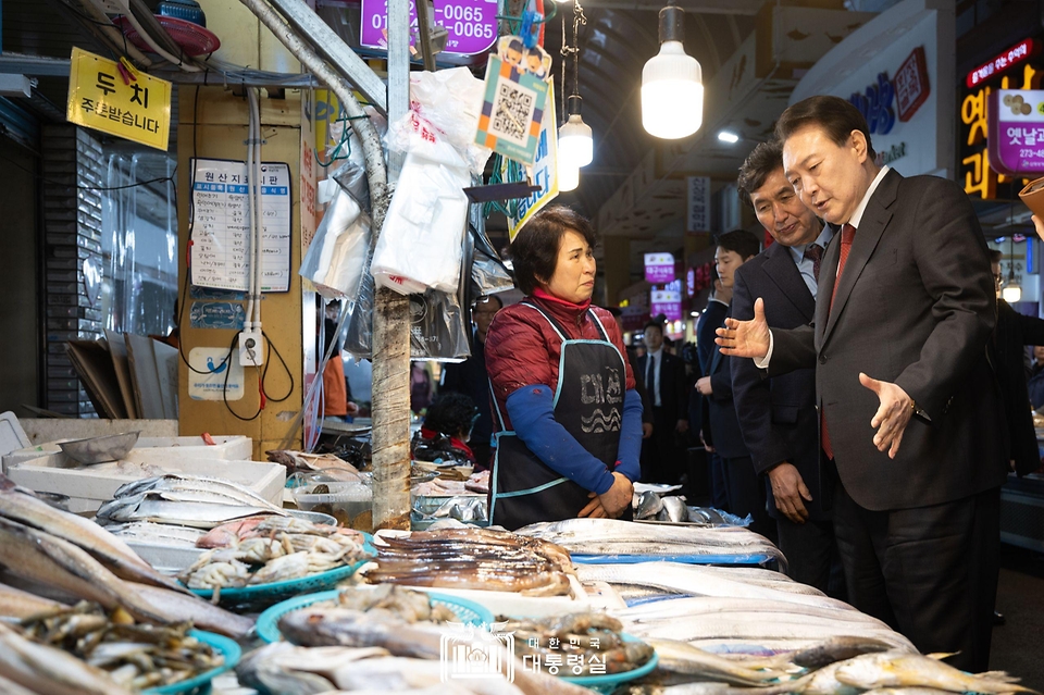 윤석열 대통령이 21일 울산 남구 신정상가시장을 방문해 상인들과 이야기를 나누고 있다.