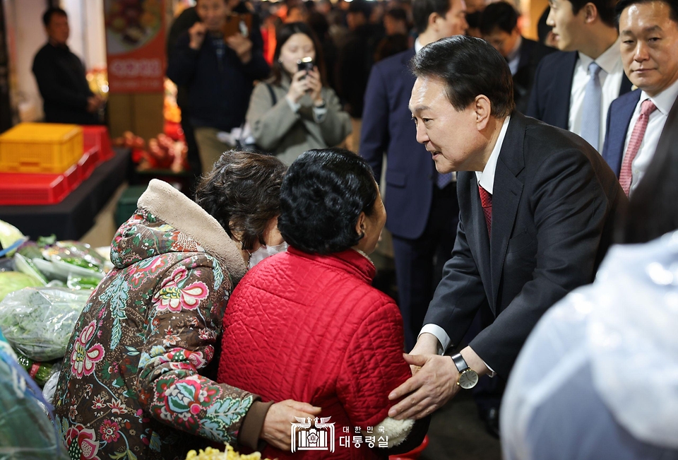 윤석열 대통령이 21일 울산 남구 신정상가시장을 방문해 시민들과 인사를 나누고 있다.