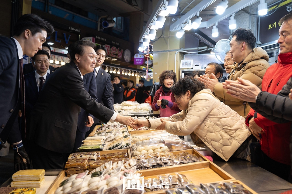 윤석열 대통령이 21일 울산 남구 신정상가시장을 방문해 상인들과 인사를 나누고 있다.