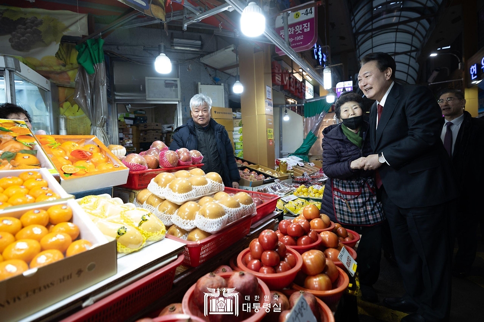 윤석열 대통령이 21일 울산 남구 신정상가시장을 방문해 과일과게에서 상인과 인사를 나누고 있다.