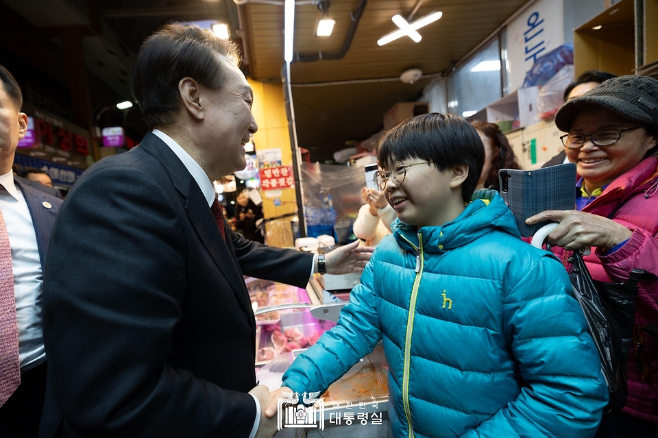 윤석열 대통령이 21일 울산 남구 신정상가시장을 방문해 시민들과 인사를 나누고 있다.