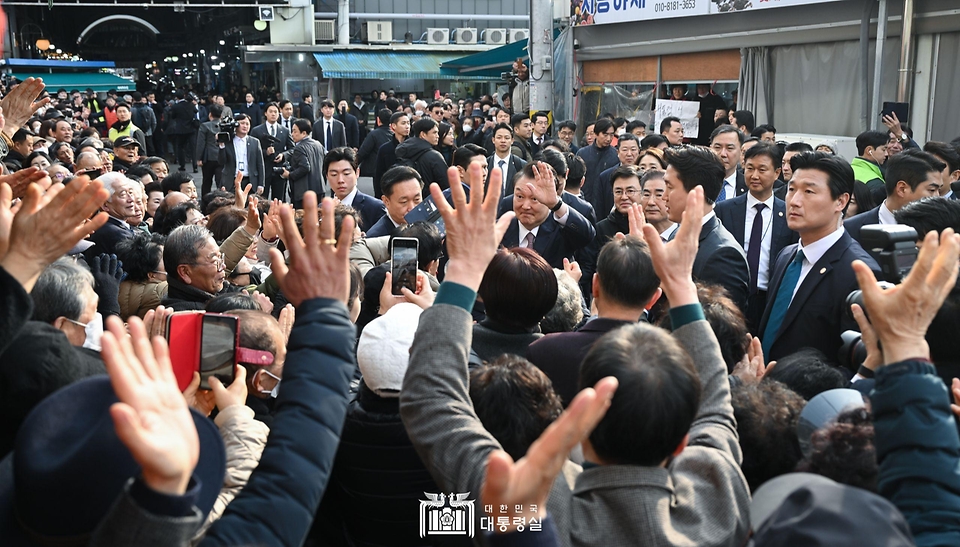 윤석열 대통령이 26일 충남 서산 동부 전통시장을 방문해 시민, 상인들과 인사하고 있다. 