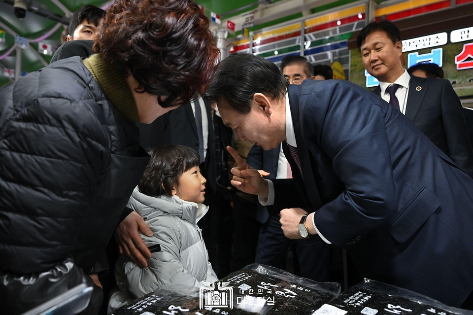 윤석열 대통령이 26일 충남 서산 동부 전통시장을 방문해 어린이와 인사하고 있다. 