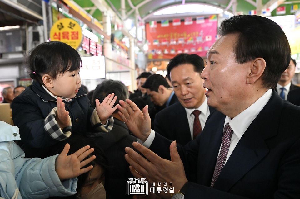 윤석열 대통령이 26일 충남 서산 동부 전통시장을 방문해 어린이와 인사하고 있다. 