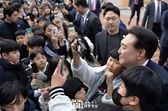 윤석열 대통령이 14일 전남 무안군 오룡초등학교 도서관에서 늘봄학교 간담회를 마친 뒤 학교를 떠나며 학생들과 기념 사진을 찍고 있다.