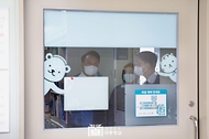 윤석열 대통령이 18일 서울 송파구 서울아산병원 어린이병원을 방문해 위생 가운을 착용한 뒤 소아혈액종양병동 내 병원학교로 들어갈 준비를 하고 있다. 