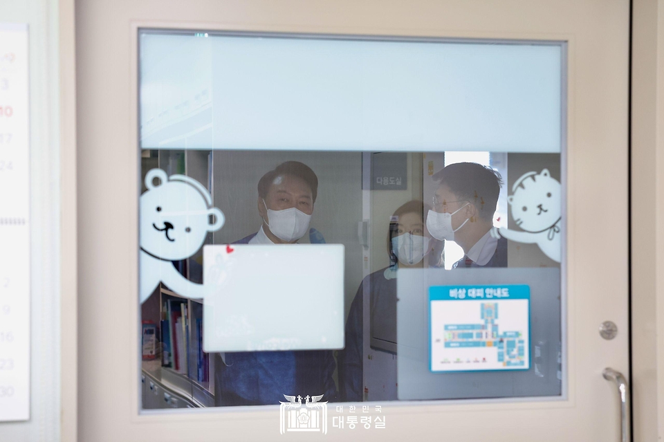 윤석열 대통령이 18일 서울 송파구 서울아산병원 어린이병원을 방문해 위생 가운을 착용한 뒤 소아혈액종양병동 내 병원학교로 들어갈 준비를 하고 있다. 