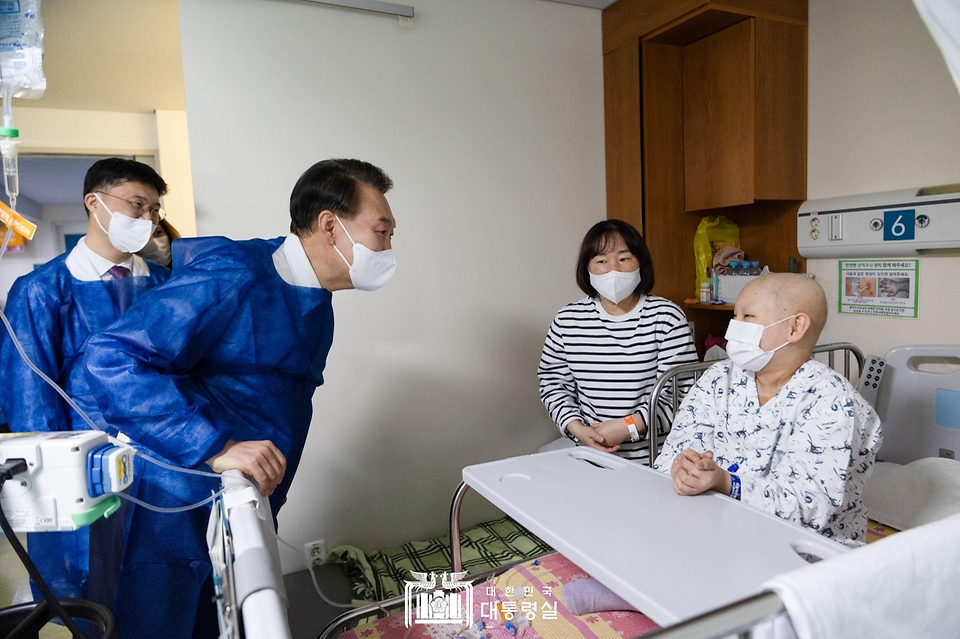 윤석열 대통령이 18일 서울 송파구 서울아산병원 어린이병원을 방문해 뇌종양 항암치료를 위해 입원 중인 한 환아를 격려하고 있다.