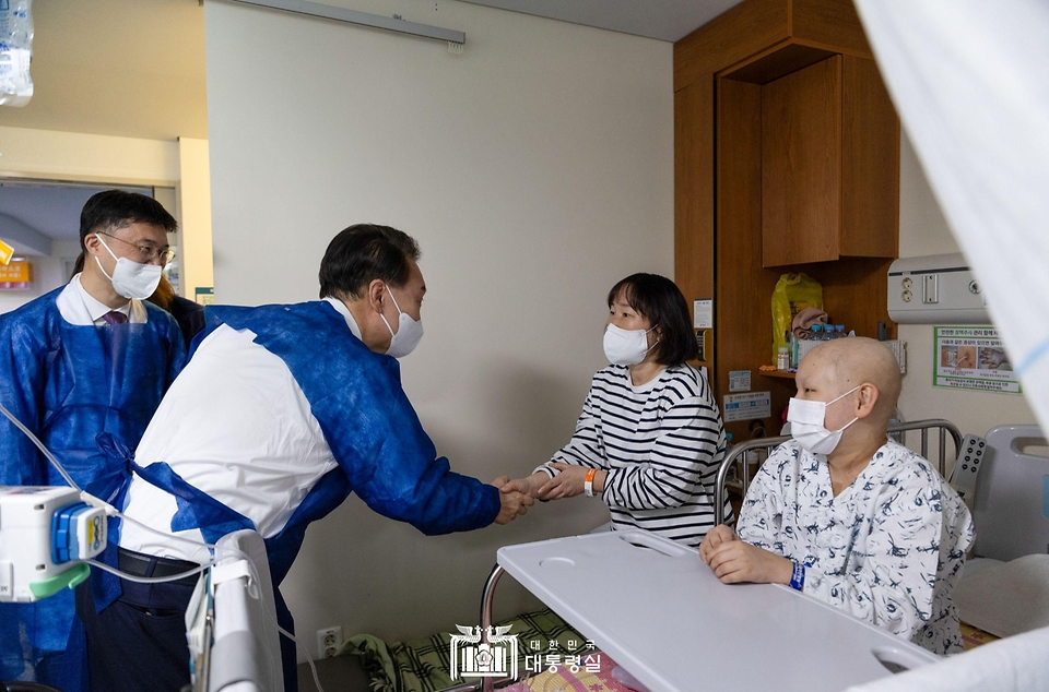 윤석열 대통령이 18일 서울 송파구 서울아산병원 어린이병원을 방문해 뇌종양 항암치료를 위해 입원 중인 한 환아와 보호자를 격려하고 있다.