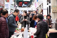 한덕수 국무총리가 21일 충남 공주시 공주산성시장에서 물건을 구입하며 소상공인들과 이야기를 나누고 있다.