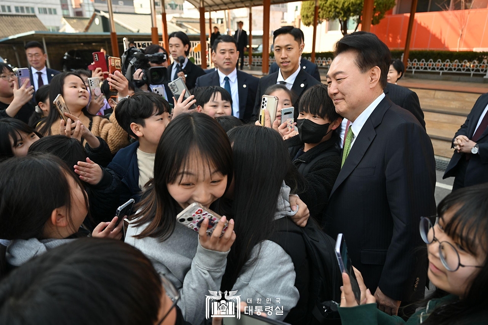 윤석열 대통령이 21일 강원도 원주시 명륜초등학교를 방문해 늘봄학교 프로그램을 참관하기 위해 이동하던 중 아이들과 만나 기념 촬영을 하고 있다.