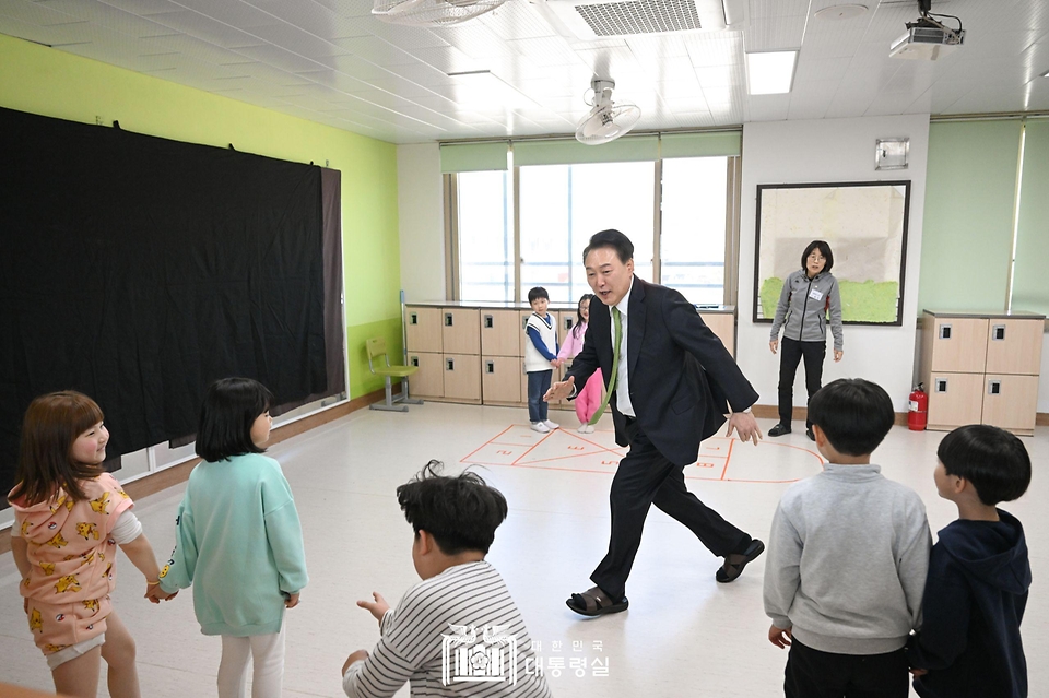 윤석열 대통령이 21일 강원도 원주시 명륜초등학교의 늘봄학교 ‘초1 맞춤형 프로그램’ 전래놀이를 진행 중인 교실에서 어린이들과 술래잡기 놀이를 함께 하고 있다.