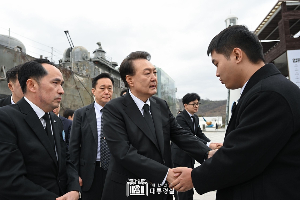 윤석열 대통령이 22일 경기도 평택 소재 해군 제2함대사령부에서 거행된 제9회 서해수호의날 기념식이 끝난 뒤 찾은 천안함 46용사 추모비 앞에서 유가족들을 위로하고 있다. 