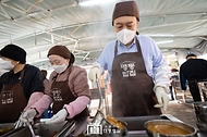윤석열 대통령이 27일 서울 명동성당 내 무료 급식소인 ‘명동밥집’을 찾아 야외 배식장에서 배식 봉사를 하고 있다.
