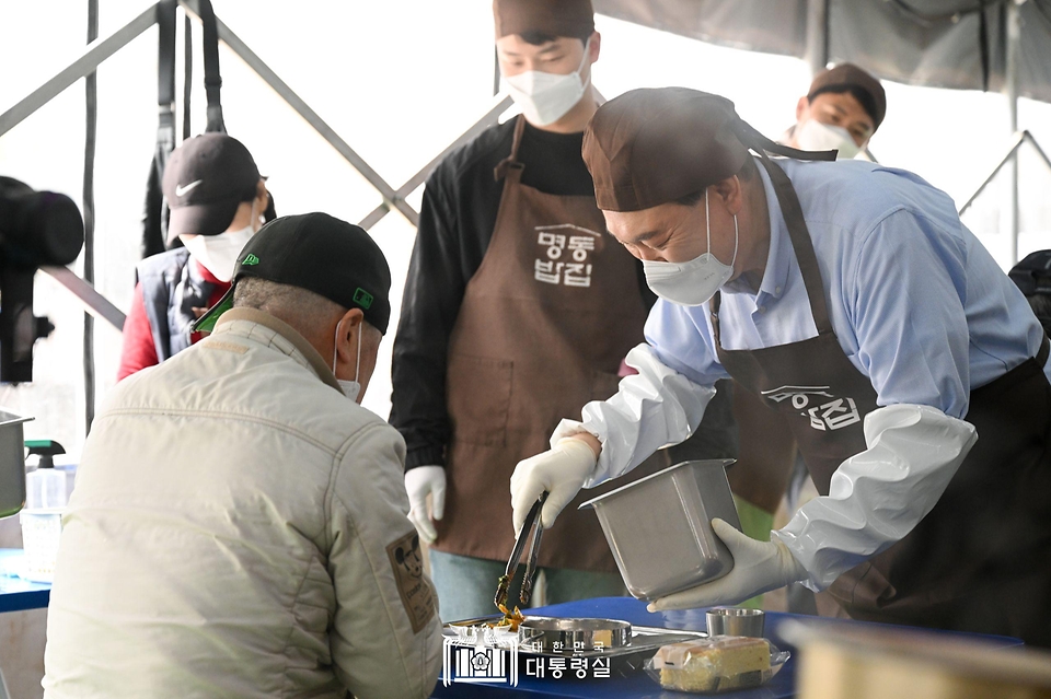 윤석열 대통령이 27일 서울 명동성당 내 무료 급식소인 ‘명동밥집’에서 봉사활동을 펼치며 추가 배식을 하고 있다.
