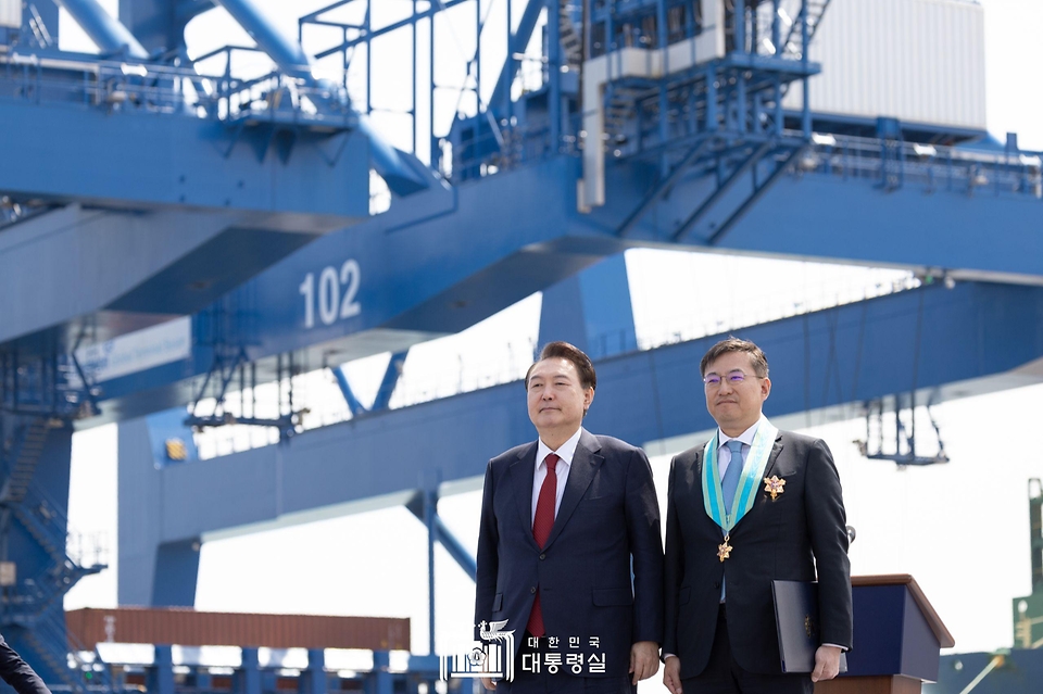윤석열 대통령이 5일 경남 창원시 진해구 부산항 신항 7부두 개장식에서 김남정 동원그룹 회장에게 은탑산업훈장을 친수한 뒤 기념 촬영을 하고 있다. 