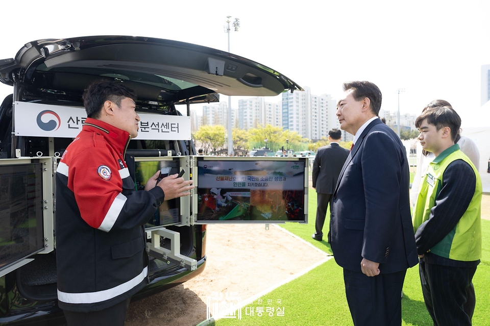 윤석열 대통령이 5일 부산 강서구 명지근린공원에서 열린 ‘제79회 식목일 기념행사’ 참석에 앞서 ‘산림재난예측 분석센터’ 부스에서 산불 방지기술에 대해 설명을 듣고 있다.