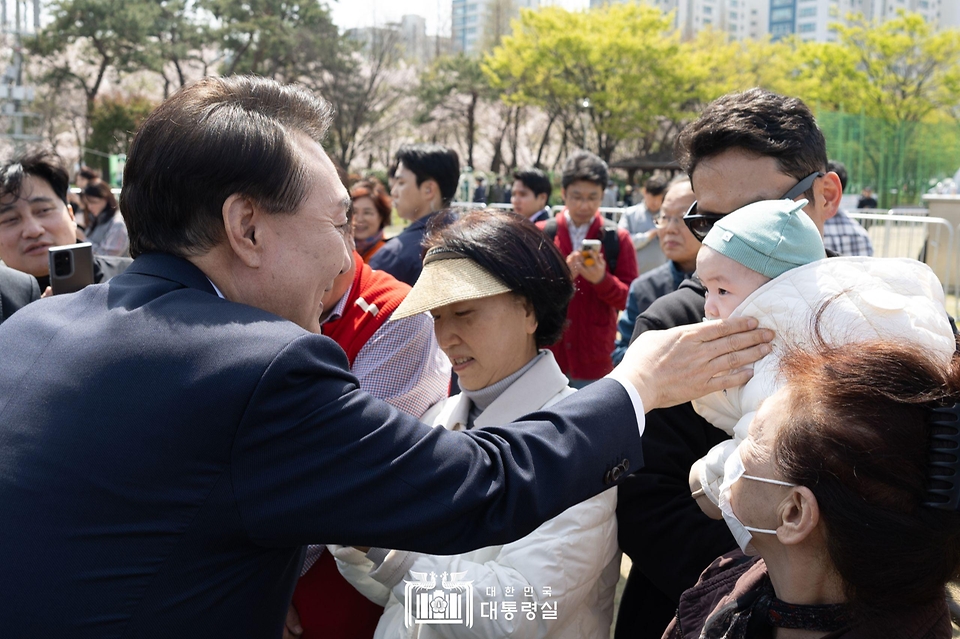 윤석열 대통령이 5일 부산 강서구 명지근린공원에서 열린 ‘제79회 식목일 기념행사’에서 아기에게 인사하고 있다.
