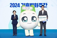 한화진 환경부 장관이 22일 서울 강남구 코엑스에서 열린 ‘2024 기후변화주간’ 개막식에서 넷마블 쿵야레스토랑즈 캐릭터 ‘쿵야’에게 탄소중립 실천 홍보대사 위촉장을 수여한 후 배민호 넷마블 MNB 대표이사와 함께 기념 촬영을 하고 있다.