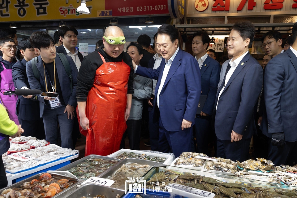 윤석열 대통령이 10일 서울 서대문구 영천시장을 찾아 수산물 가게에서 상인을 격려하고 있다.