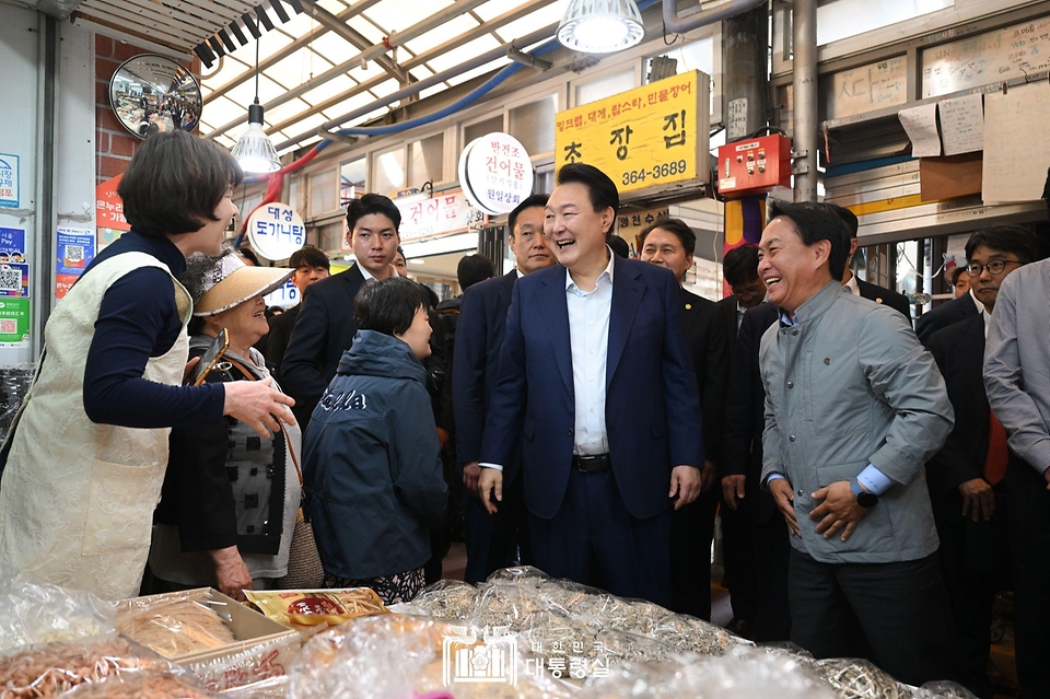 윤석열 대통령이 10일 서울 서대문구 영천시장을 찾아 한 점포에서 상인과 인사하고 있다. 
