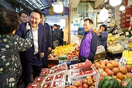 윤석열 대통령이 10일 서울 서대문구 영천시장을 찾아 과일을 파는 점포에서 한 시민과 인사하고 있다. 