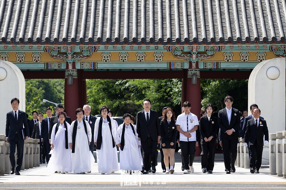 윤석열 대통령이 18일 광주시 북구 국립 5·18민주묘지에서 열린 ‘제44주년 5·18민주화운동 기념식’에 참석해 5·18 유가족 대표들과 함께 ‘민주의문’을 지나 입장하고 있다.
