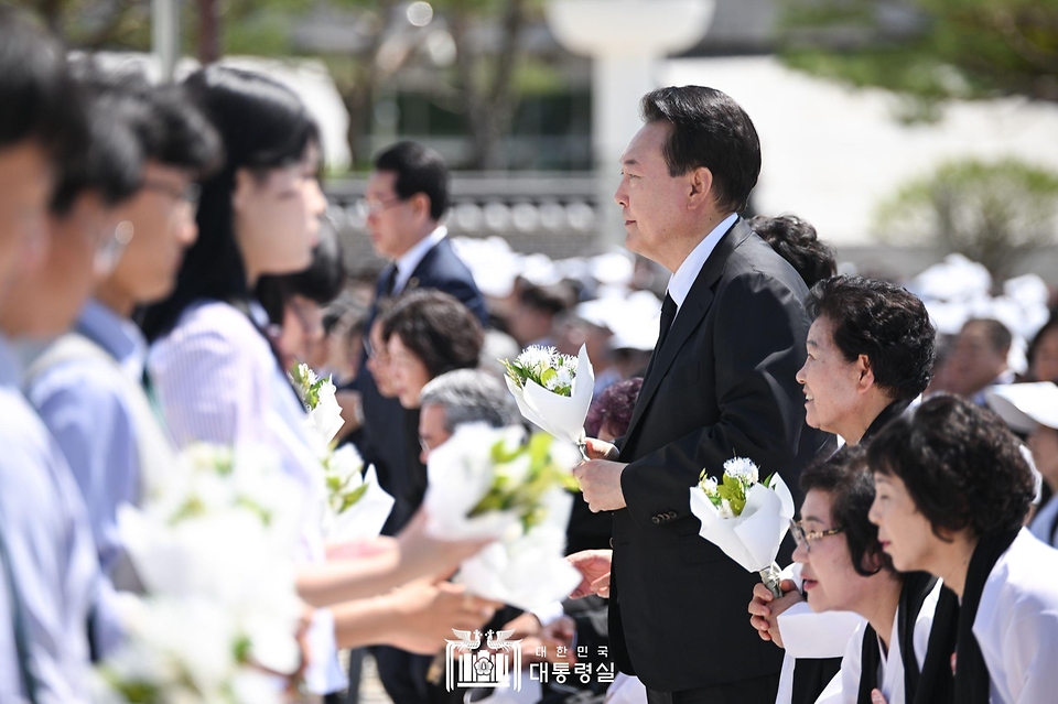 윤석열 대통령이 18일 광주시 북구 국립 5·18민주묘지에서 열린 ‘제44주년 5·18민주화운동 기념식’에 참석해 학생 대표로부터 ‘5·18 상징꽃’인 이팝나무 꽃다발을 전달 받고 있다.