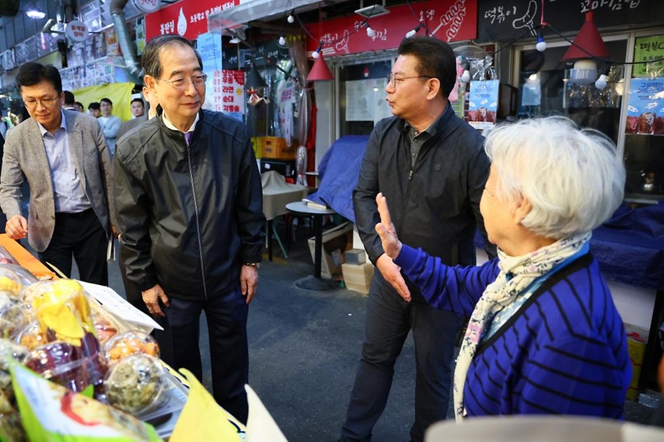 한덕수 국무총리가 20일 서울 종로구 통인시장을 방문해 점포를 돌아보며 상인들과 대화를 나누고 있다.