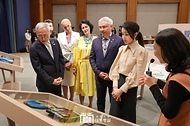 김건희 여사가 21일 청와대 춘추관에서 열린 ‘희망을 그리는 아이들: 우크라이나 아동 그림전’을 찾아 우크라이나 어린이 60명이 참여한 프로젝트로, 전쟁에서 사용된 방탄판 위에 그림을 얹힌 형태의 예술품을 전시한 ‘설치물 존’의 발레리아 스트로쥬크 ‘빼앗긴 어린 시절’에 대한 설명을 듣고 있다. 