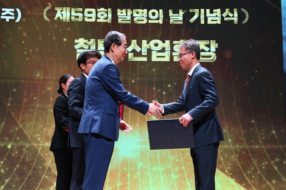 한덕수 국무총리가 21일 서울 중구 대한상공회의소에서 열린 ‘제59회 발명의 날 기념식’에서 김종환 SK하이닉스 부사장에게 철탑 산업훈장을 수여하고 있다.