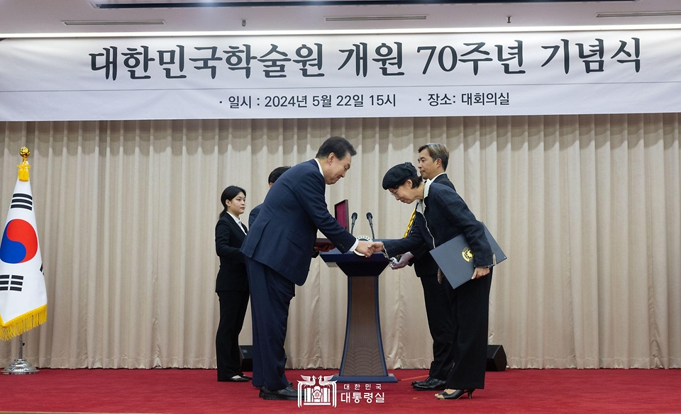 윤석열 대통령이 22일 서울 서초구 대한민국학술원에서 열린 개원 70주년 기념식에서 인문학 분야 고(故) 장석진 회원 배우자에게 국민훈장 무궁화장을 수여하고 있다. 