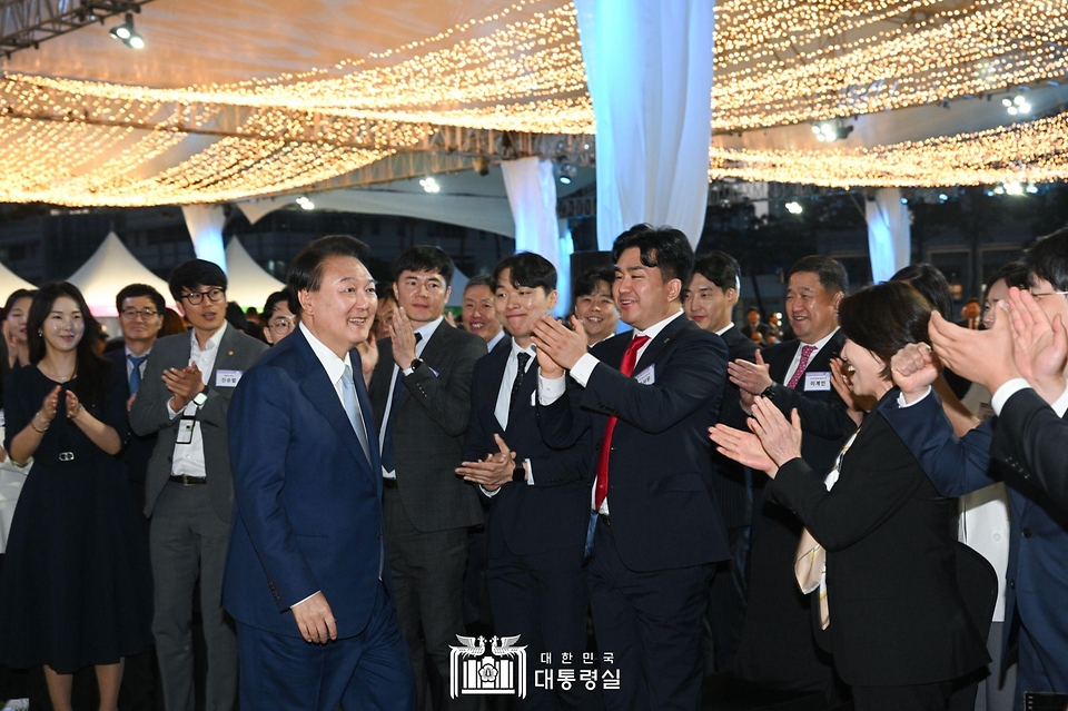 윤석열 대통령이 23일 서울 용산 대통령실 잔디마당에서 열린 ‘2024 대한민국 중소기업인대회’에서 참석자들과 기념 촬영을 위해 이동하고 있다.