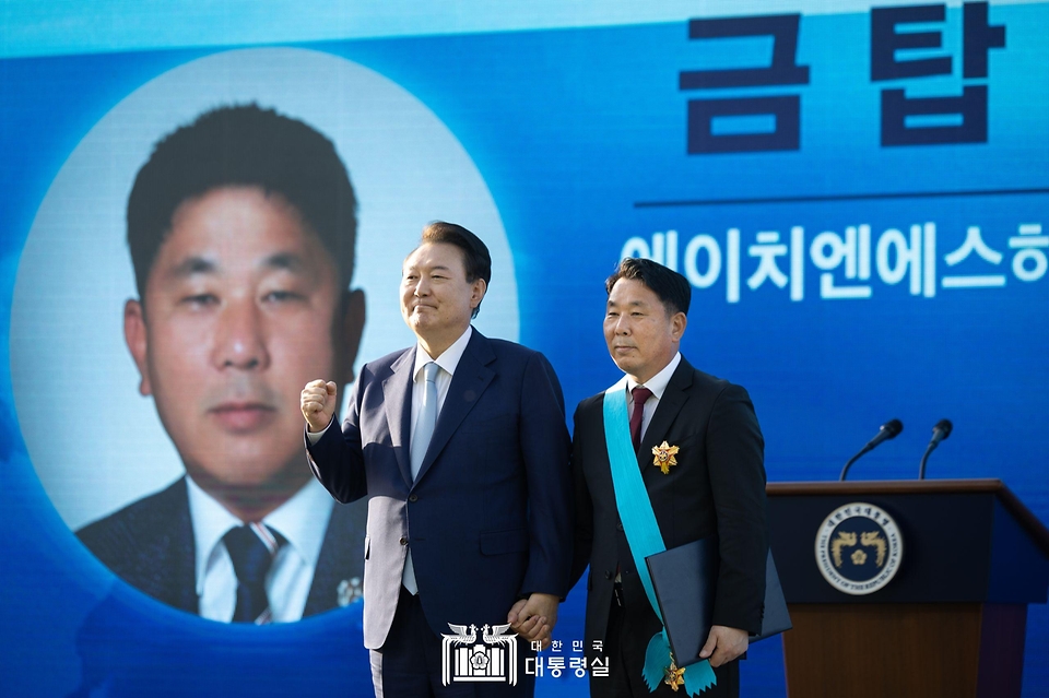 윤석열 대통령이 23일 서울 용산 대통령실 잔디마당에서 열린 ‘2024 대한민국 중소기업인대회’에서 김정희 에이치엔에스하이텍 대표에게 금탑산업훈장을 포상한 뒤 기념 촬영을 하고 있다. 