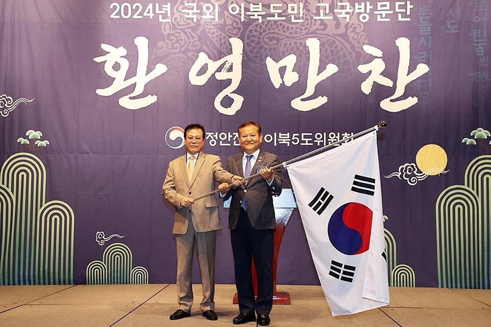 이상민 행정안전부 장관이 28일 서울 중구 웨스틴조선 호텔에서 열린 ‘제30차 국외 이북도민 고국방문단 행사’에 참석해 방문단 대표에게 태극기 선물을 전달하고 있다.