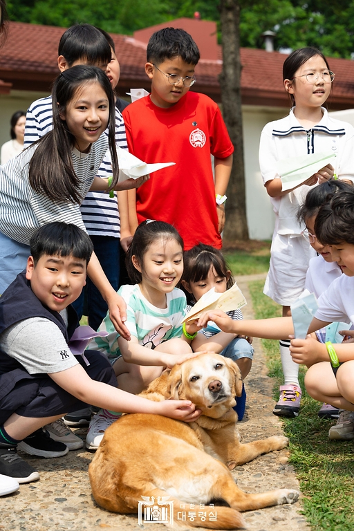 어린이들이 5일 서울 용산어린이정원에서 열린 ‘어린이 환경·생태 교육관’ 개관 행사에서 김건희 여사의 반려견 새롬이를 쓰다듬고 있다.