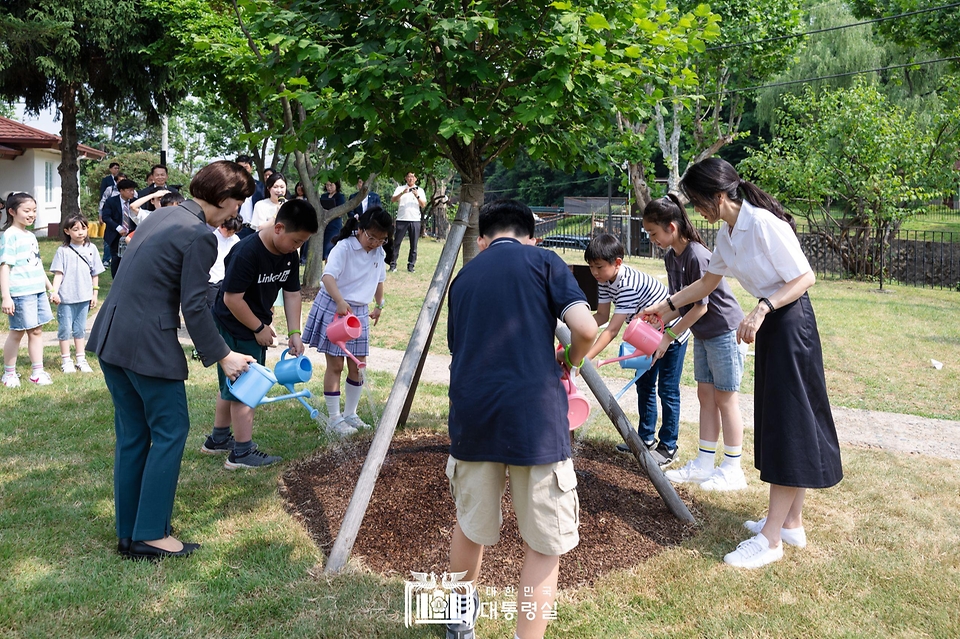 김건희 여사가 5일 서울 용산어린이정원에서 열린 ‘어린이 환경·생태 교육관’ 개관 행사에서 지난해 방한한 제인구달 박사가 식수한 산사나무에 물을 주고 있다. 
